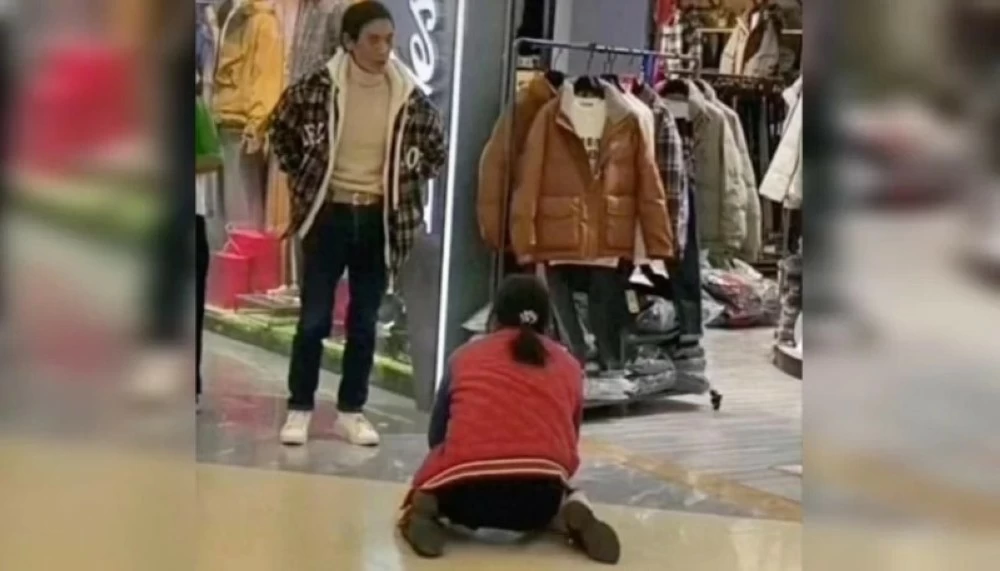 امرأة تجثو على ركبتيها وتتوسل زوجها لشراء «جاكيت»